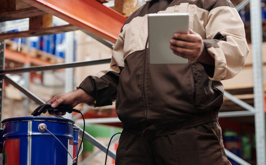 Warehouse specialist checking stock against a specification on a tablet